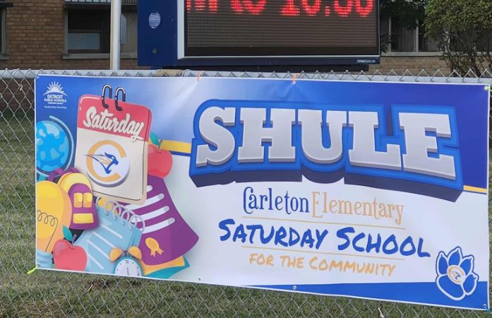 SHULE sign in colorful signs hanging outside of Carleton Elementary. 
